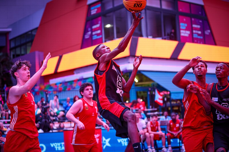 During a game, a player leaps for the ball as his opponents and teammates look up.