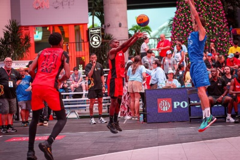 A player leaps into the air, attempting to pass the ball as his opponent attempts to block