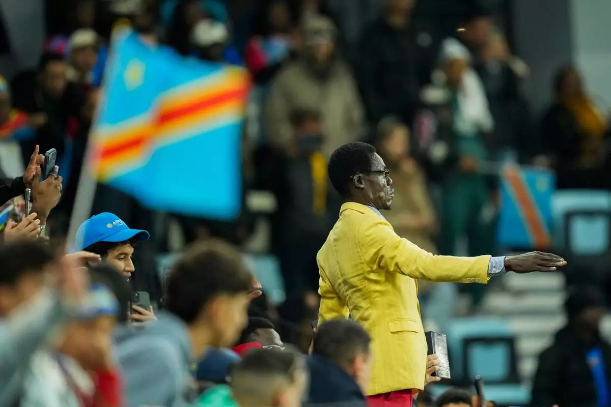 Michel Nkuka Mboladinga, a DR Congo fan impersonating late Congolese leader Patrice Lumumba, strikes a pose during the Africa Cup of Nations group D soccer match between Botswana and DR Congo in Rabat, Morocco, Tuesday, Dec. 30, 2025. (AP Photo/Mosa'ab Elshamy)