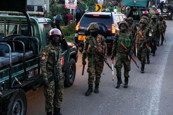 Ugandan security forces patrol a street during a campaign rally for opposition presidential candidate Robert Kyagulanyi Ssentamu who is known as Bobi Wine, ahead of elections, in Mukono, Uganda, Friday, Jan. 9, 2026. (AP Photo/Hajarah Nalwadda)
