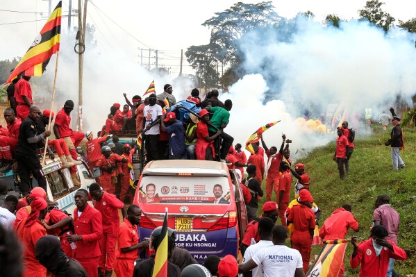 Supporters of Ugandan opposition presidential candidate Robert Kyagulanyi Ssentamu who is known as Bobi Wine are tear-gassed by police during a campaign rally ahead of elections, in Mukono, Uganda, Friday, Jan. 9, 2026. (AP Photo/Hajarah Nalwadda)