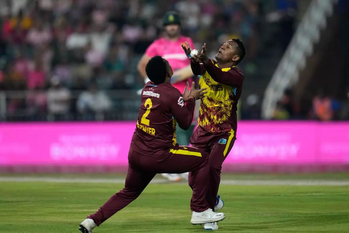 West Indies bowler Akeal Hosein, right, takes a catch to dismiss South Africa's batsman Aiden Markram during the T20 International cricket match between South Africa and West Indies, in Johannesburg, South Africa, Saturday, Jan. 31, 2026. (AP Photo/Themba Hadebe)