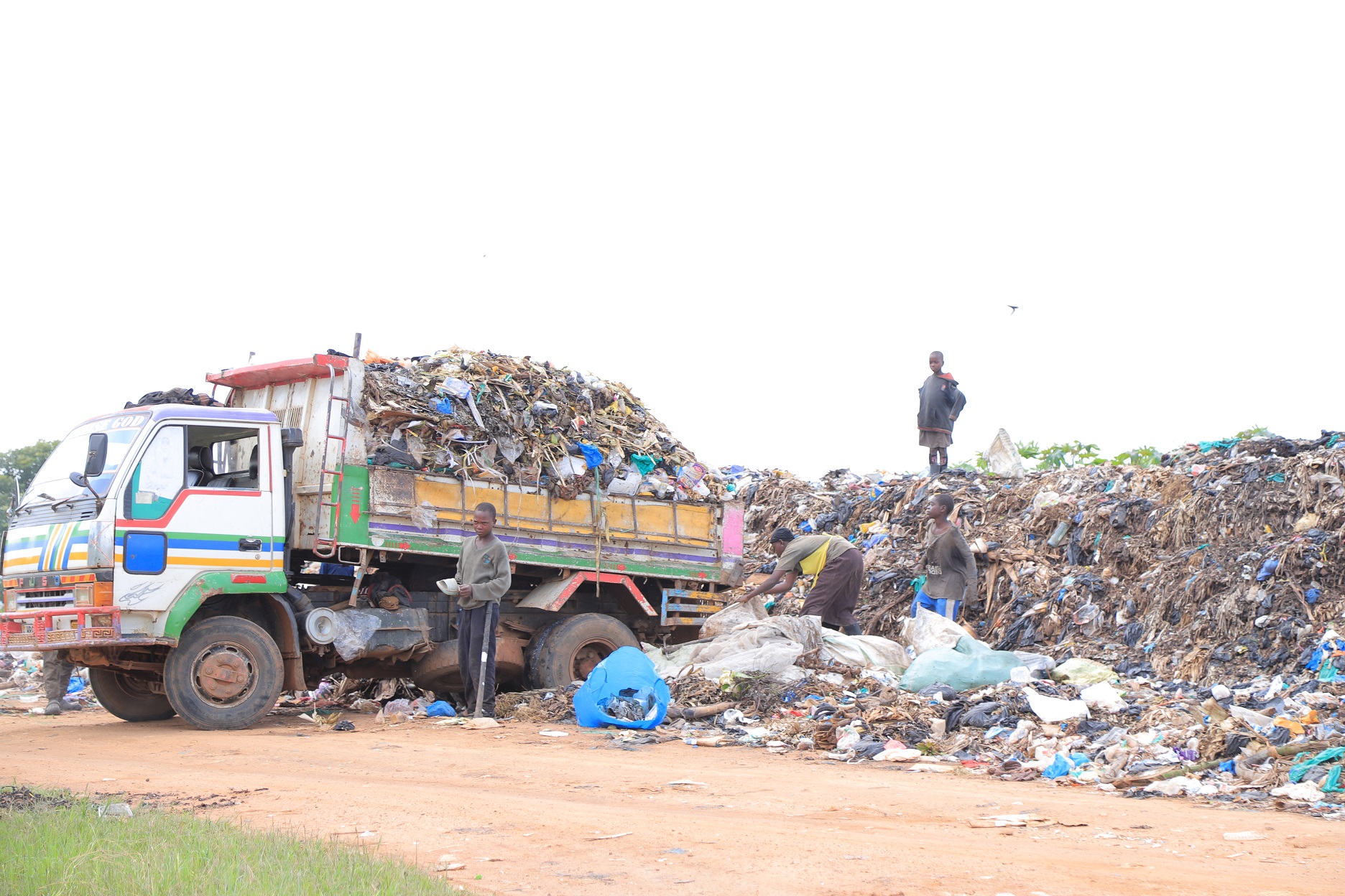 A garbage truck tips off garbage by the roadside in Kenkombe.