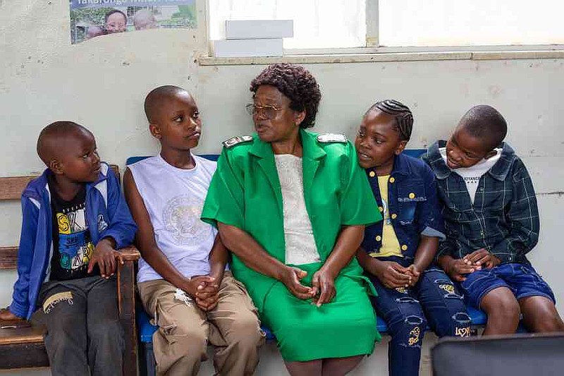 A nurse talks to young girls before they received free doses of the HPV vaccine at Budiriro Polyclinic in Harare, Zimbabwe, Saturday, Jan. 17, 2026. (AP Photo/Aaron Ufumeli)