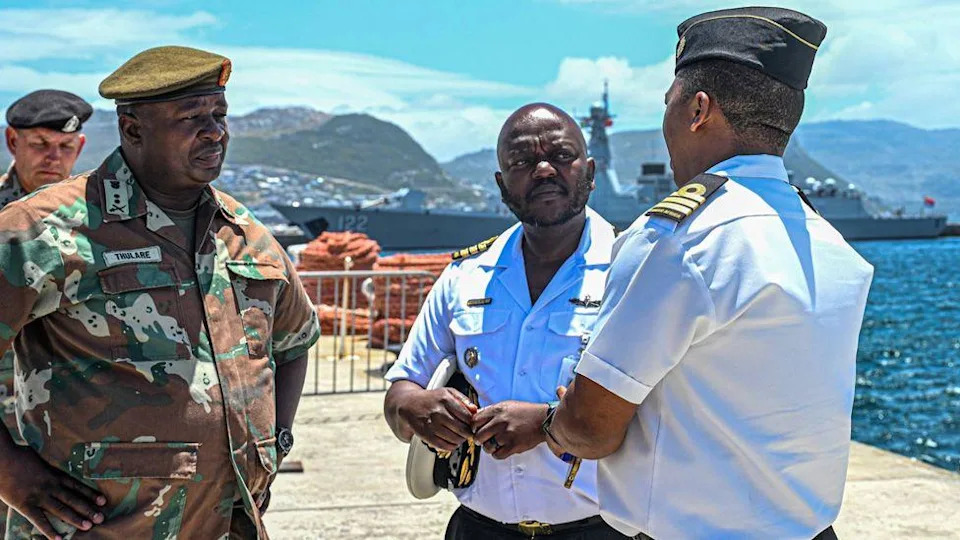 South African army and naval officers pictured in Simon's Town harbour with ships behind them