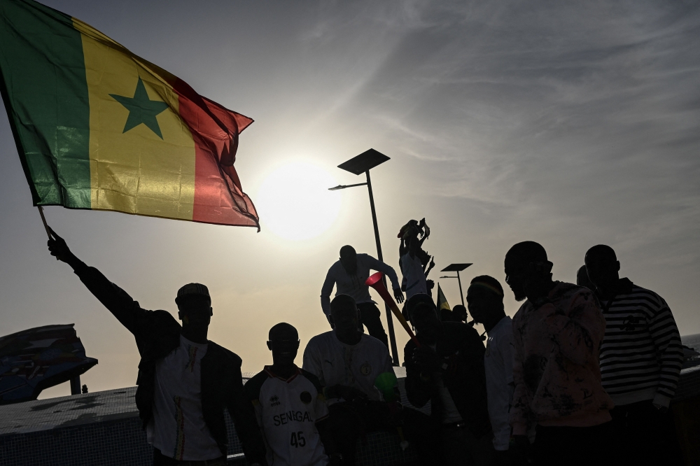 A Senegal football supporter waves a Senegalese flag at the Place du Souvenir Africain in Dakar on January 18, 2026 as supporters gather at a fan zone to watch the Africa Cup of Nations final football match between Senegal and Morocco played in Rabat, Morocco. — AFP pic
