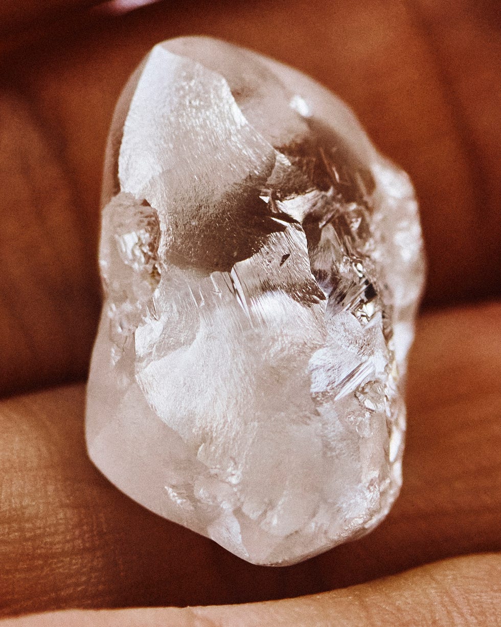 clear quartz crystal held in a hand