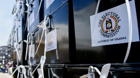 Reuters A close-up of a stack of ballot boxes sealed with plastic ties. Stickers for the electoral commission can be seen on them.