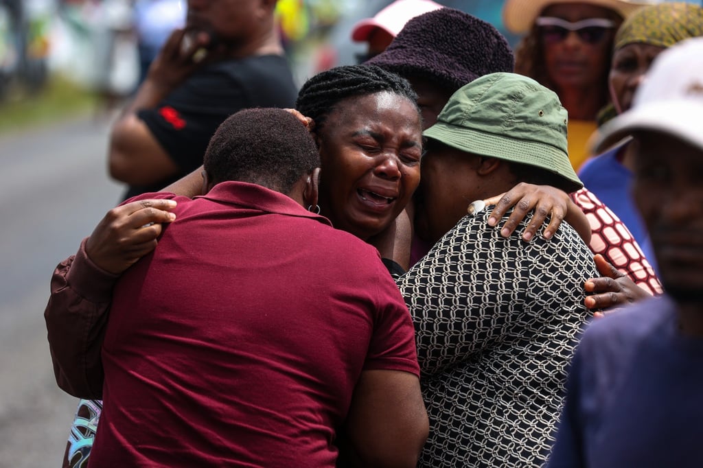 Relatives of children who died when the minibus they were riding in collided with a truck, weep at the scene of the crash on Monday. Photo: AP