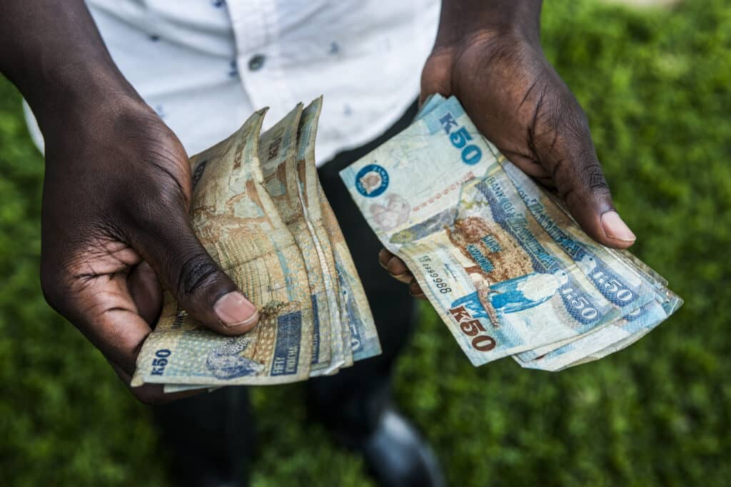 A man counts out Zambian kwacha