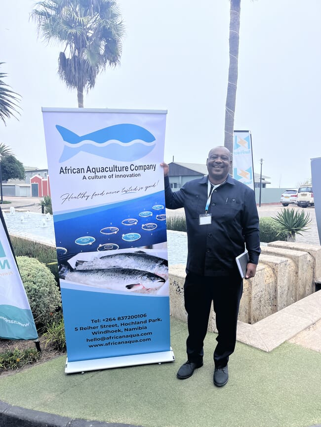 A man standing beside a sign.