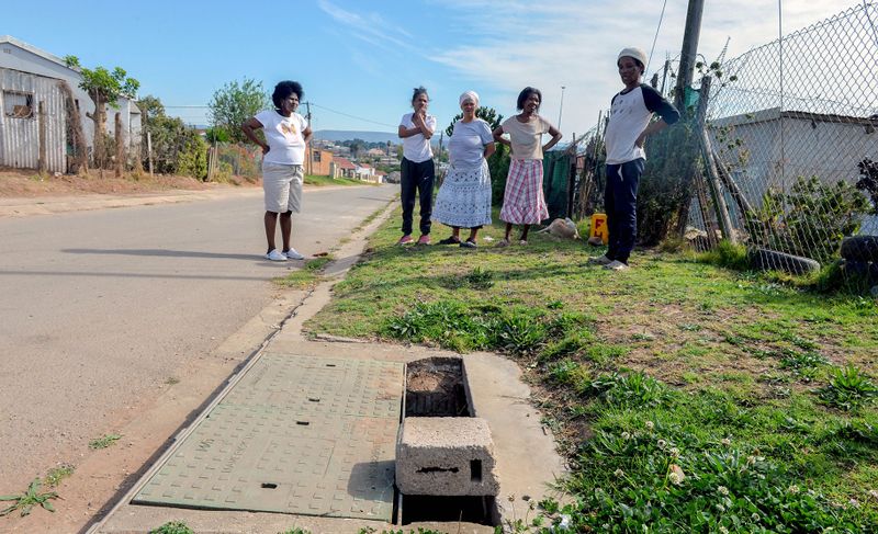 Residents of Grootboom Street, where a toddler drowned in a broken drain in September 2014. While the drain was fixed in 2021, part of the cover has once again been vandalised. (Photo: Deon Ferreira)
