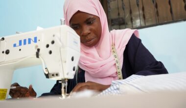 A woman in a pink headscarf leans over a sewing machine at the Arizona Vocational Center in Dar es Salaam, Tanzania.