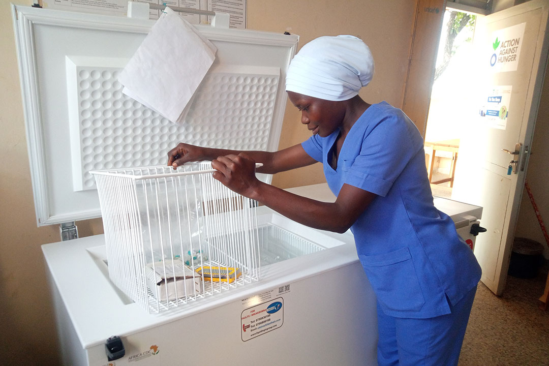 Hindum Afakoru, an enrolled Nurse at Jomorogo health centre III opens the refrigerator where HPV vaccines are kept. Credit: John Musenze