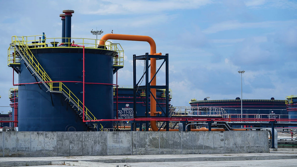 A large dark-blue tank has several brightly colored pipes emerging from its top and snaking out of the picture.