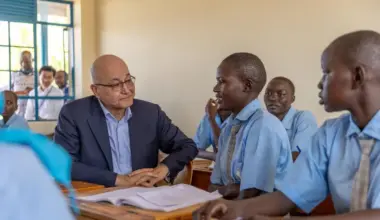 UN High Commissioner for Refugees Barham Salih speaks with female students sitting in a classroom at The Big Heart Foundation Secondary School in Kakuma, Kenya.