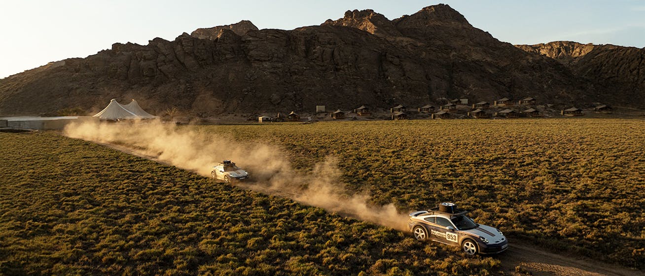 Convoy of Porsche 911 Dakar cars driving through Nambian desert