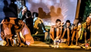 Suspected human trafficking victims sit on a pavement in Mulbarton in the south of Johannesburg on Monday night before being assisted by police and private security. (Photo: Aneesa Adams)