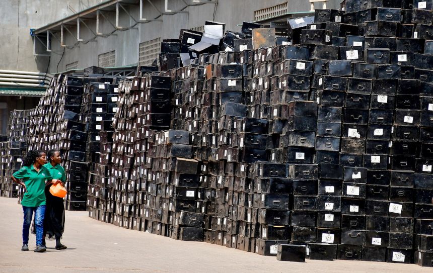 Workers walk past boxes containing electoral materials before their distribution from the Uganda Electoral Commission warehouse, ahead of the country's general election, in Ntinda suburb of Kampala, Uganda, on January 8.