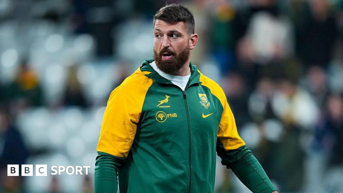 Jean Kleyn wearing South Africa training leisure kit, walking on the pitch while looking over his right shoulder before a match for the country