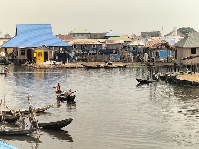 Photo de pêcheurs et habitants en pirogue dans la lagune de Ganvié, au Bénin. Ce type d’environnement, où l’eau douce est omniprésente et les contacts humains fréquents, constitue un terrain propice à la transmission de la bilharziose.