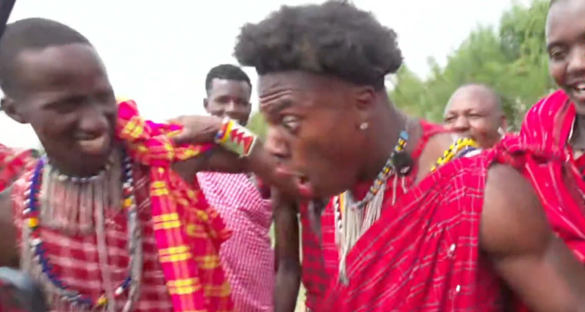 IShowSpeed sits on stage, holding microphone at event.