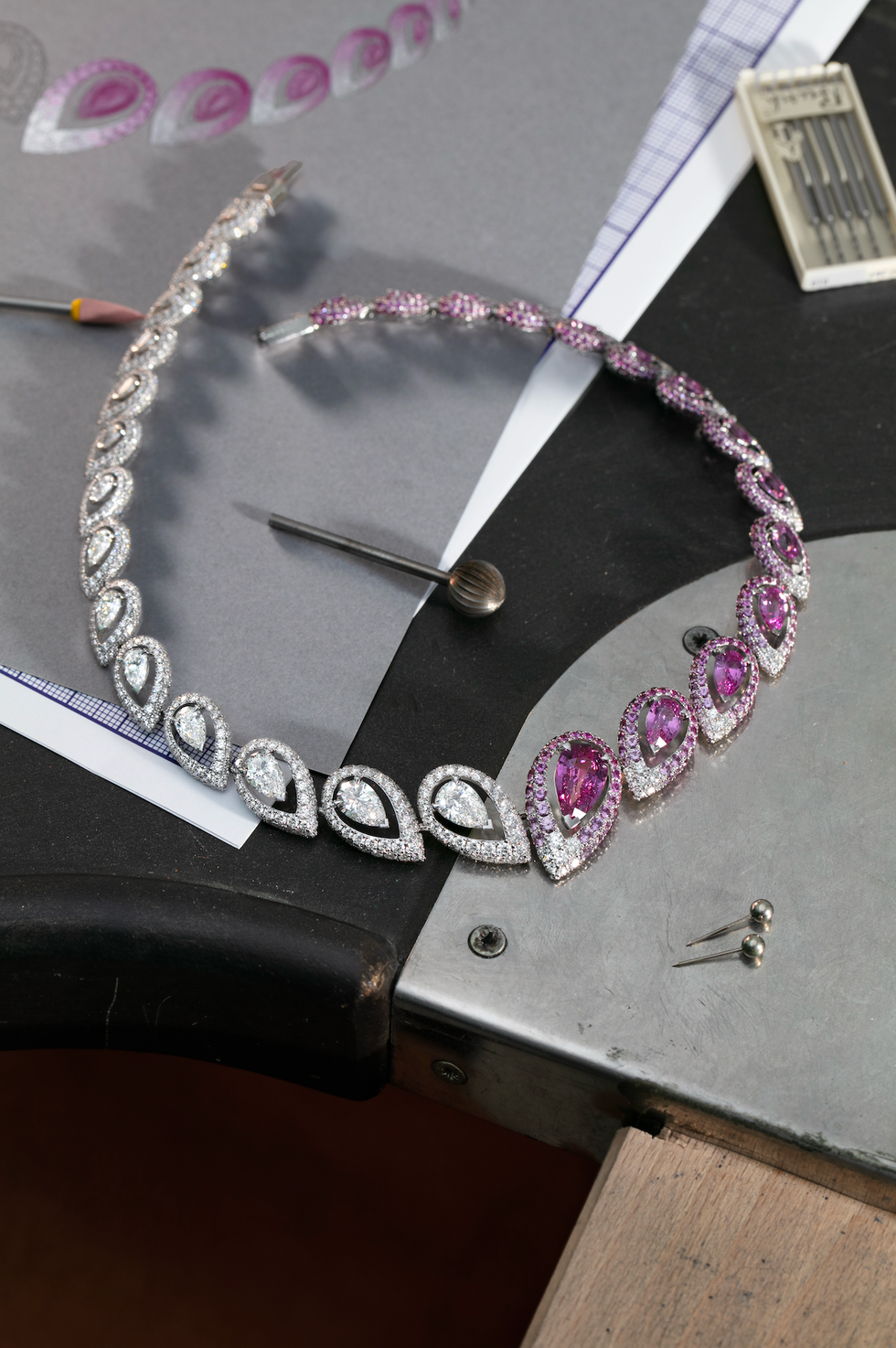 jewelry pieces and design sketches on a work table