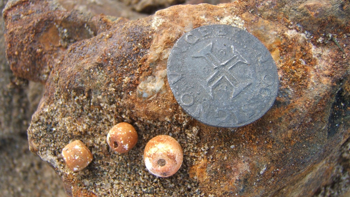 A coin and rosary beads discovered in the Namibian shipwreck 