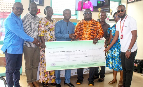 Richard Yeboah (left), from Happy Family Home Orphanage, receiving the cheque from Stephen Amugyah, CEO, Samugyah Praise Foundation, on behalf of the orphanage. Looking on are officials of the foundation and children at the orphanage  Picture: ERNEST KODZI