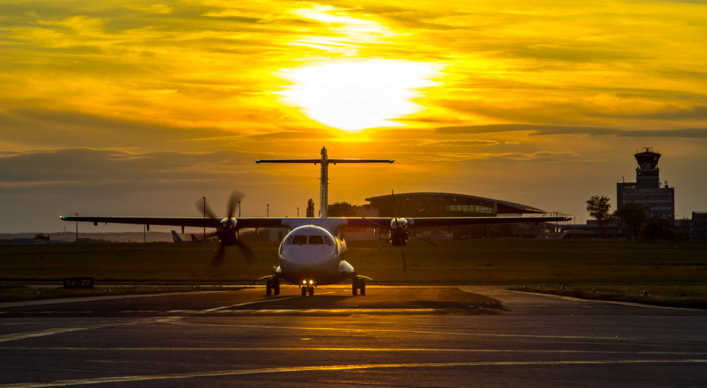 An ATR 42 in the sunset taxiing at the airport.