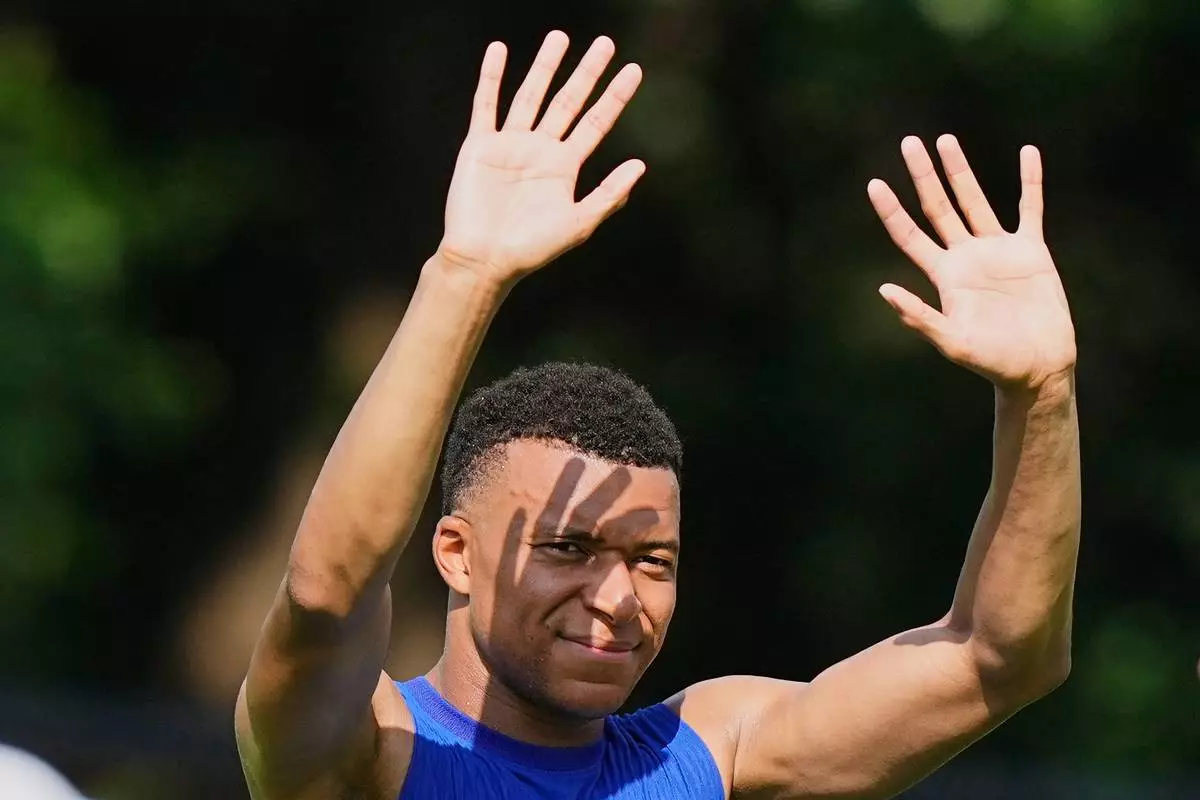 France's Kylian Mbappe reacts to fans in the hot sun during a training session during the FIFA World Cup soccer tournament, at the France base camp in Waltham, Mass., near Boston, Friday, June 12, 2026. (AP Photo/Martin Meissner)