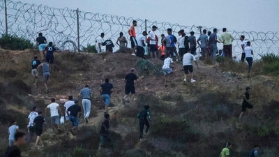 People gather on a hilltop near Bab Sebta on the Morocco-Spain border, near Spain's enclave of Ceuta and the Moroccan town of Fnideq on July 30, 2026. (Photo by Abdelmajid BZIOUAT / AFP) (AFP)