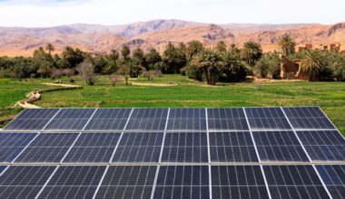 Solar panels with mountains in the background.