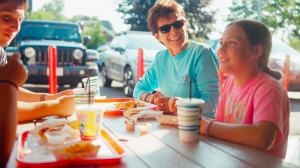 Smiling family enjoying a meal at Connors Hotdog Stand in the Town of Evans
