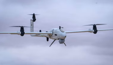 An unmanned aerial system flies in the air on a cloudy day.