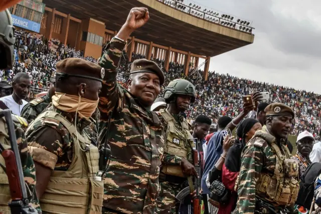 Le général Abdourahamane Tiani (2e à gauche), chef du régime militaire nigérien, salue la foule de milliers de personnes rassemblées au plus grand stade de Niamey pour le lancement des festivités marquant le premier anniversaire de son arrivée au pouvoir après le coup d'État du 26 juillet 2023 qui a renversé le président civil Mohamed Bazoum. 