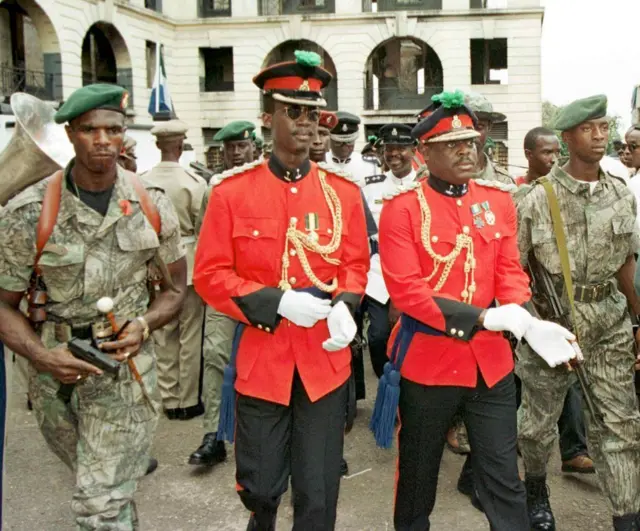 Photo datée du 09 novembre 1997 de Johnny Paul Koroma (2e R), l'ancien chef de la junte militaire qui a pris le pouvoir en Sierra Leone, et de son Premier ministre Solomon Saj ​​​​Musa (2e L) à Freetown. 