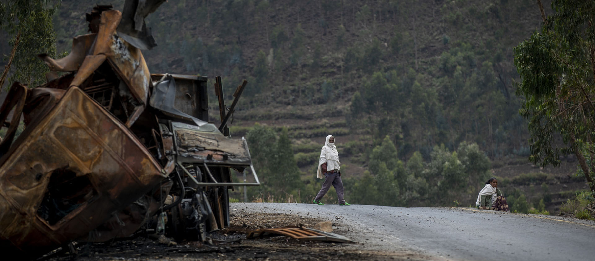 Un homme passe près d'un camion détruit sur une route menant à la ville d'Abi Adi, dans la région du Tigré, au nord de l'Éthiopie, le 11 mai 2021