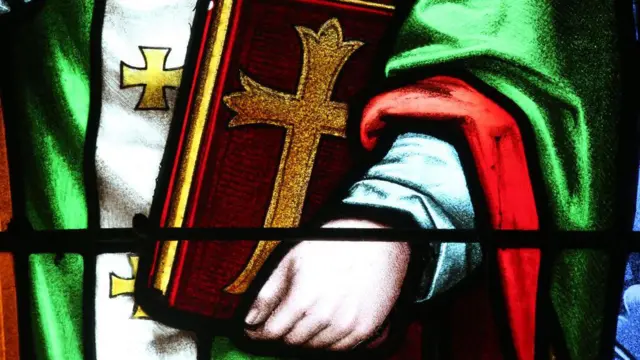 Un vitrail représentant Saint Augustin d'Hippone tenant une bible.