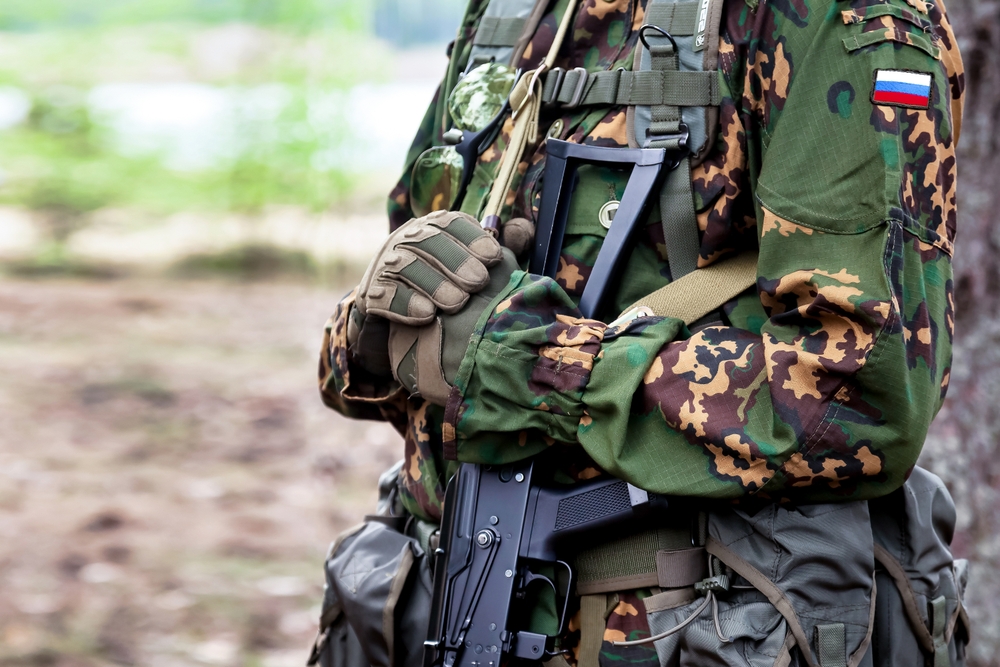 Soldat de l’armée russe en uniforme de camouflage avec une mitrailleuse