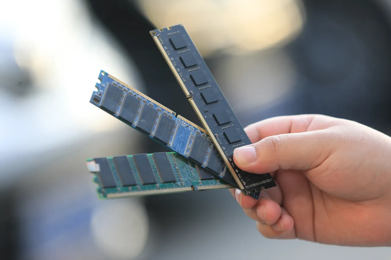A staff member at a computer parts shop displays memory modules. (Photo by VCG/VCG via Getty Images)