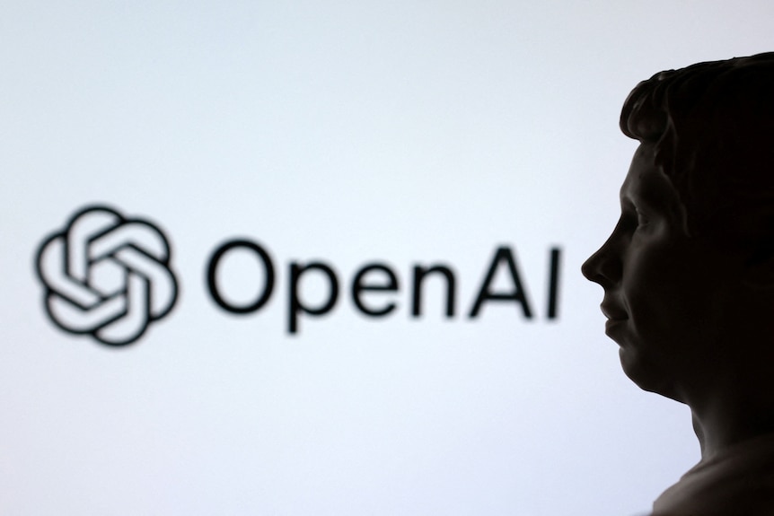 Sam Altman standing in front of the OpenAI logo.