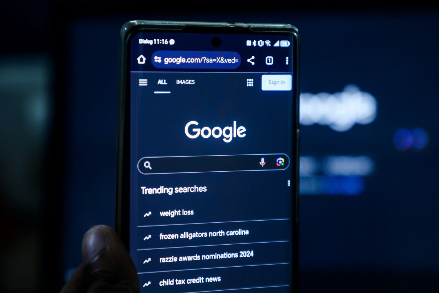A phone showing the Google search screen against a dark backdrop