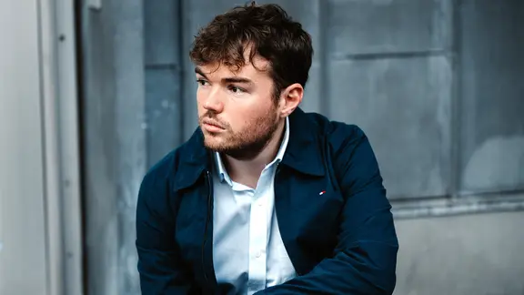 Ein junger Mann mit dunklen welligen Haaren schaut nachdenklich zur Seite (Foto des Musikers Timothy Ridout) | Jiyang Chen, Jiyang Chen Ein junger Mann mit dunklen welligen Haaren schaut nachdenklich zur Seite (Foto des Musikers Timothy Ridout)