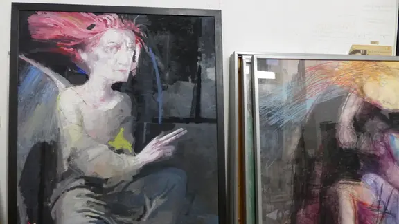Frauen waren ein Leben lang Hauptmotiv: ihre Kraft, ihre Sinnlichkeit, ihr Ausdruck | MDR/Lonamedia Blick in ein Atelier, mehrere Gemälde lehnen an einer Wand, auf einem ist eine Frauenfigur mit roten langen Haaren abgebildet