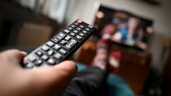 Eine Fernbedienung wird Richtung Fernseher gehalten. | picture alliance/dpa/dpa-Zentralbild | Britta Pedersen, Britta Pedersen Eine Fernbedienung wird Richtung Fernseher gehalten.