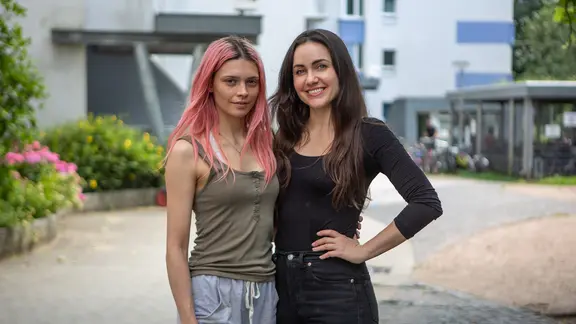 Drehstart für NDR „Nordlichter“-Film „Mama?“ mit Harriet Herbig-Matten (l.) und Katharina Sporrer. | NDR/Anna-Katharina Kolkmann Zwei junge Frau stehen vor einem Häuserblock und schauen in die Kamera