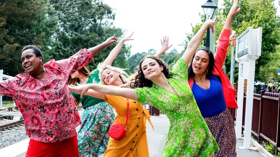 Vier Frauen tanzen in bunten Klamotten. | BBC Studios/Arte Vier Frauen tanzen in bunten Klamotten.