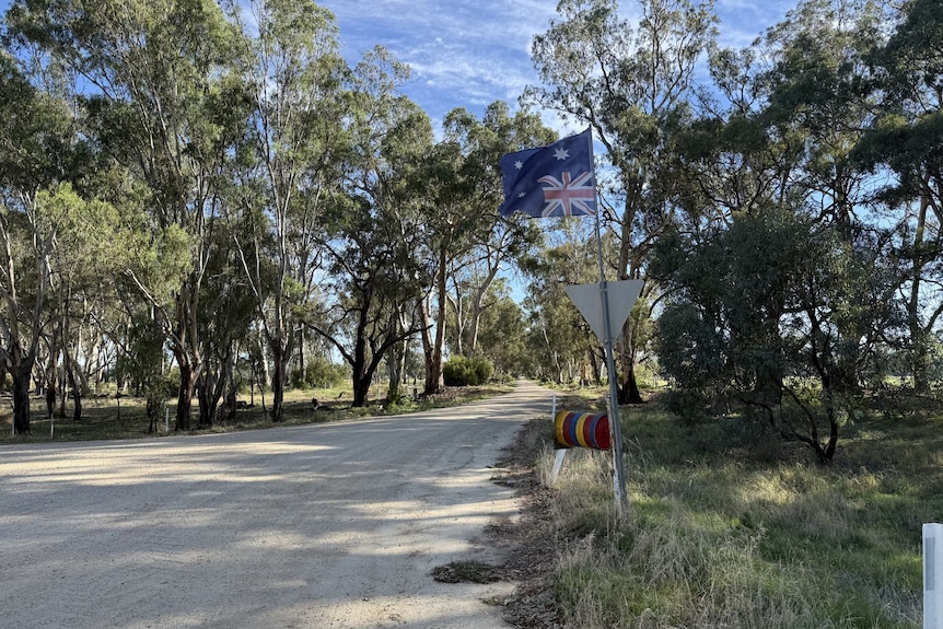 An upside-down flag displayed next to a country road.