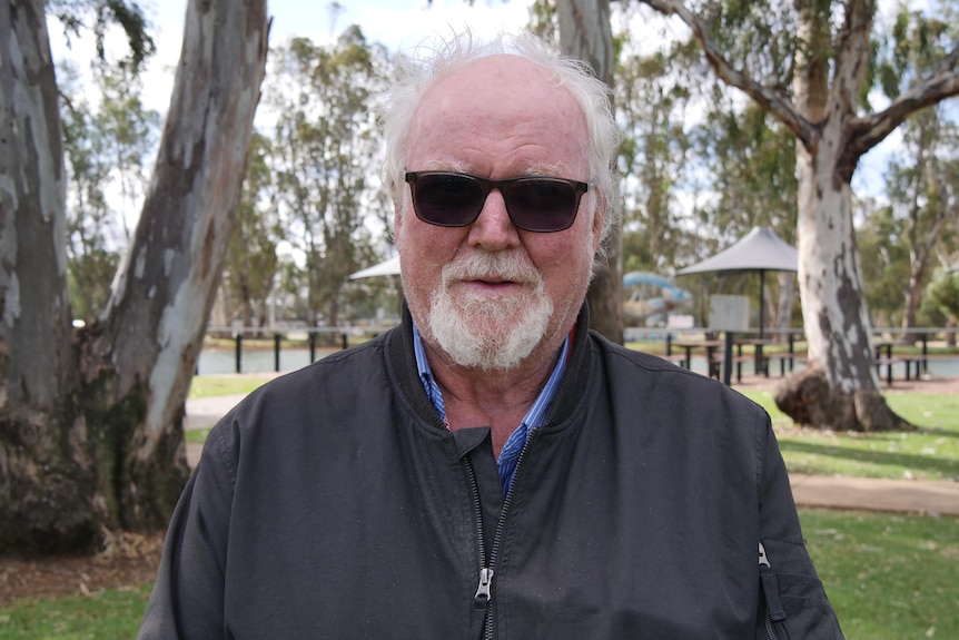 man with grey hair wearing dark sunglasses